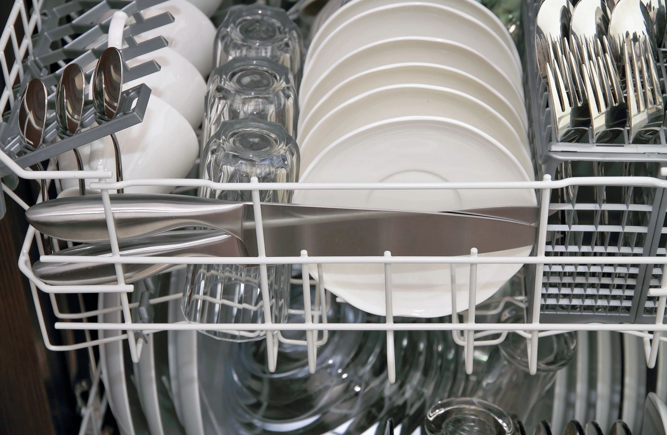 Open dishwasher loaded with clean dishes